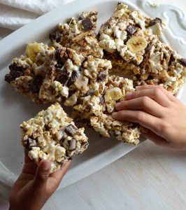 Movie night just got even better with these Chunky Monkey Popcorn Bars! Popcorn marshmallow bars filled with chocolate chunks, banana chips and walnuts. This dessert snack recipe will be a fun family treat!