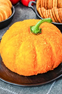 prepared pumpkin shaped cheese ball on platter