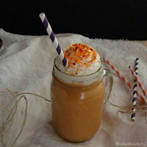 overhead view of glass jar with orange drink, whipped cream and orange sugar crystals