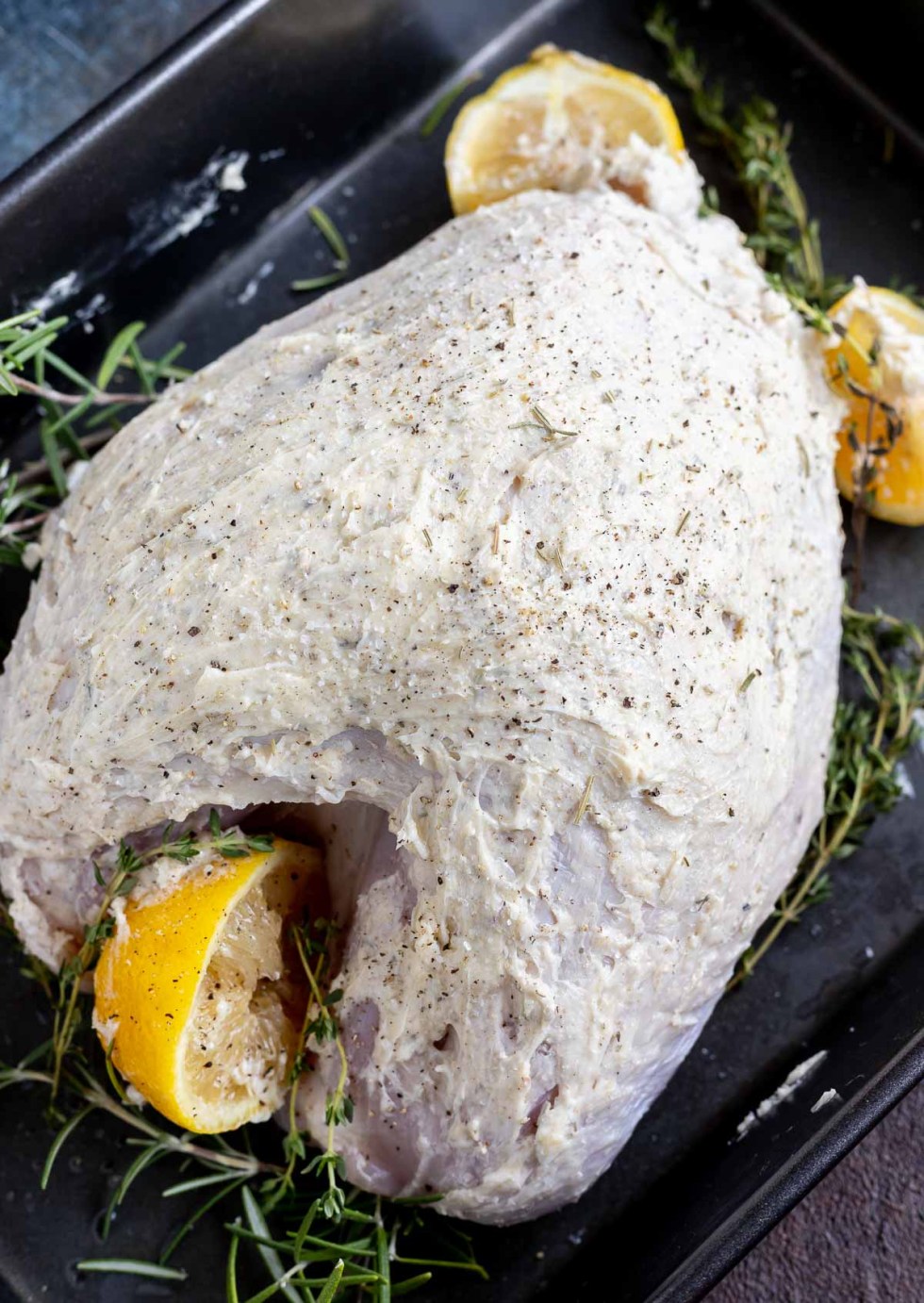 raw turkey breast coated with butter in pan