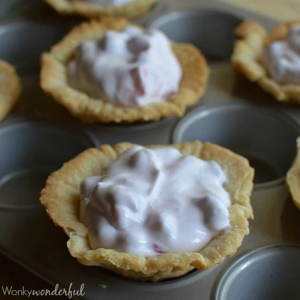 baked mini pie crusts filled with creamy pink mixture