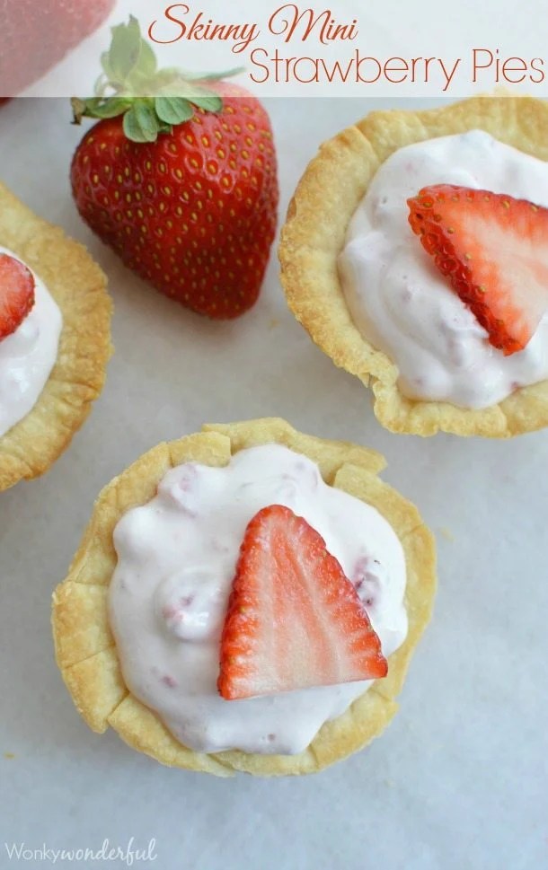 mini pie crusts filled with creamy pink mixture topped with strawberry slices - photo text: skinny mini strawberry pies