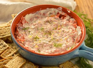 smoked salmon dip served in light blue dish with crackers on the side