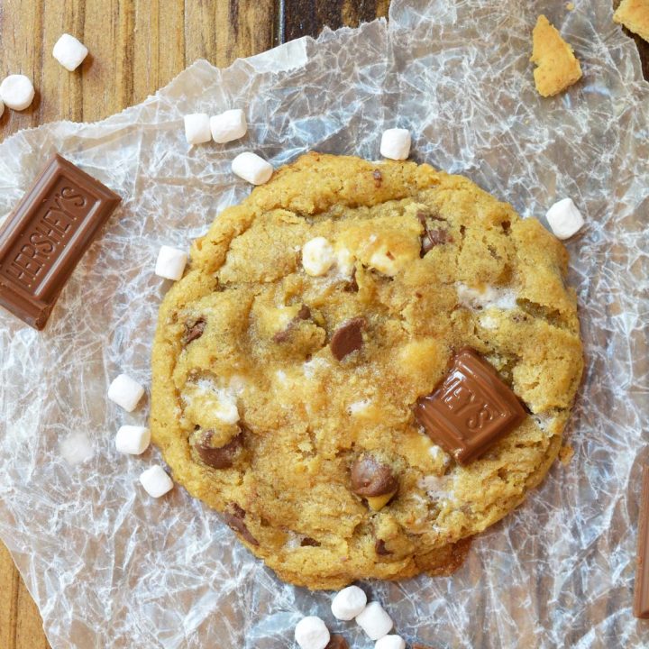 This fun twist on your favorite cookie is filled with S'mores goodness. S'mores Chewy Chocolate Chip Cookies make a great summertime dessert that can be enjoyed inside or outside! Marshmallows, chocolate and graham crackers make this super chewy cookie recipe extra special.