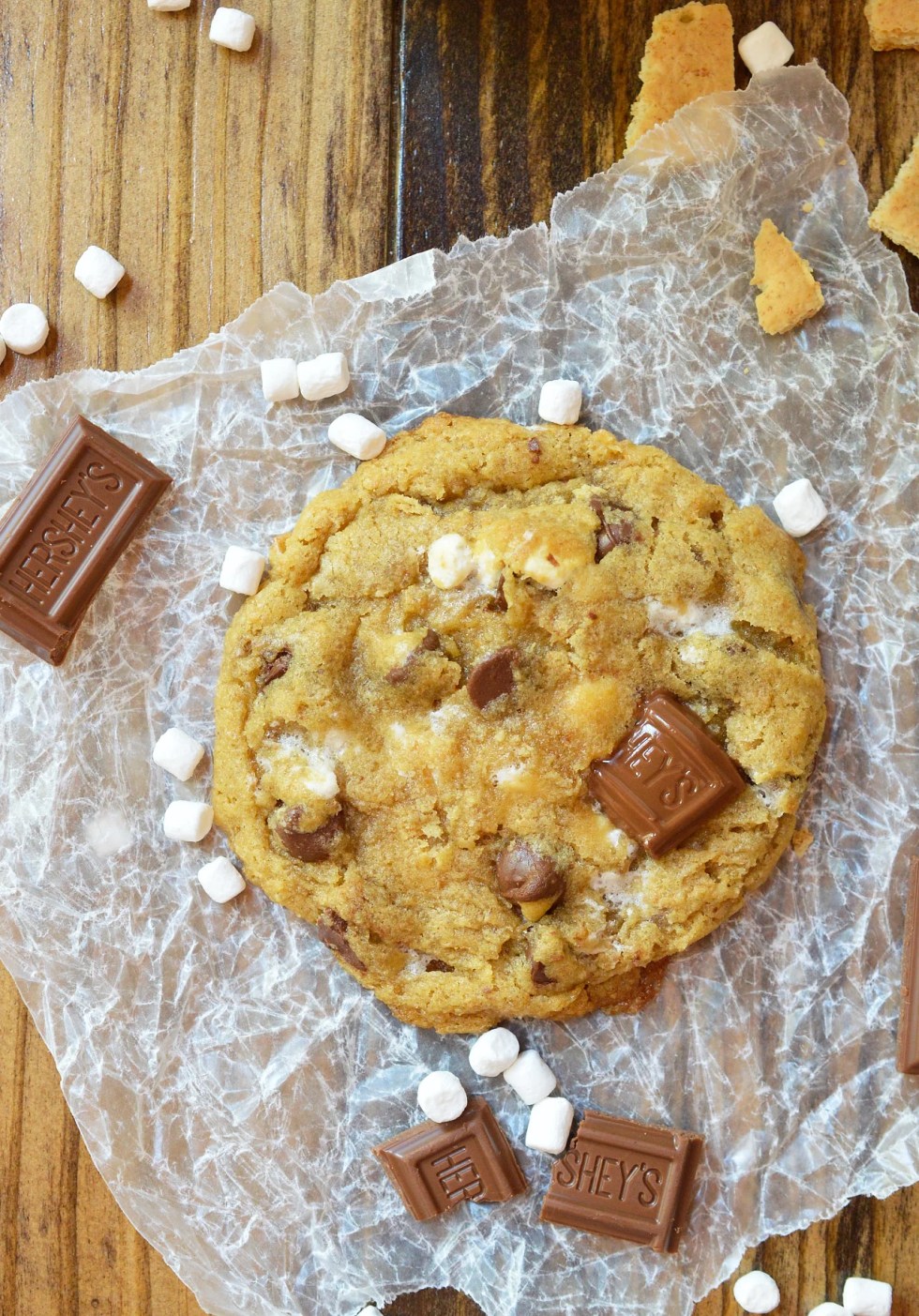 This fun twist on your favorite cookie is filled with S'mores goodness. S'mores Chewy Chocolate Chip Cookies make a great summertime dessert that can be enjoyed inside or outside! Marshmallows, chocolate and graham crackers make this super chewy cookie recipe extra special.