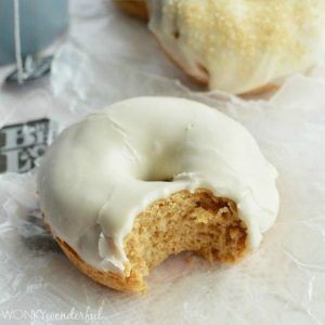 tan baked donut with white glaze and bite taken out