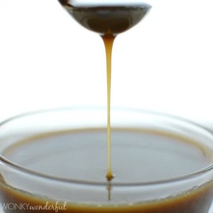 spoon drizzling golden brown caramel sauce