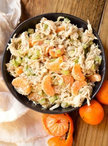 chicken salad With celery chunks and mandarin segments in black bowl